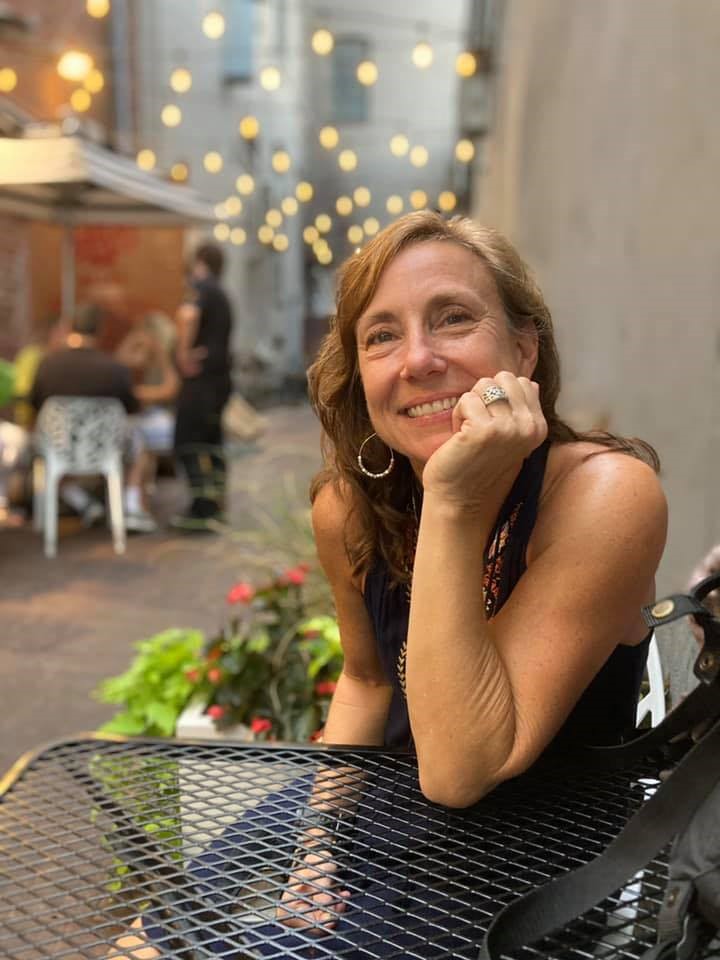 Jennifer Holloway, assise à une table, sourit.