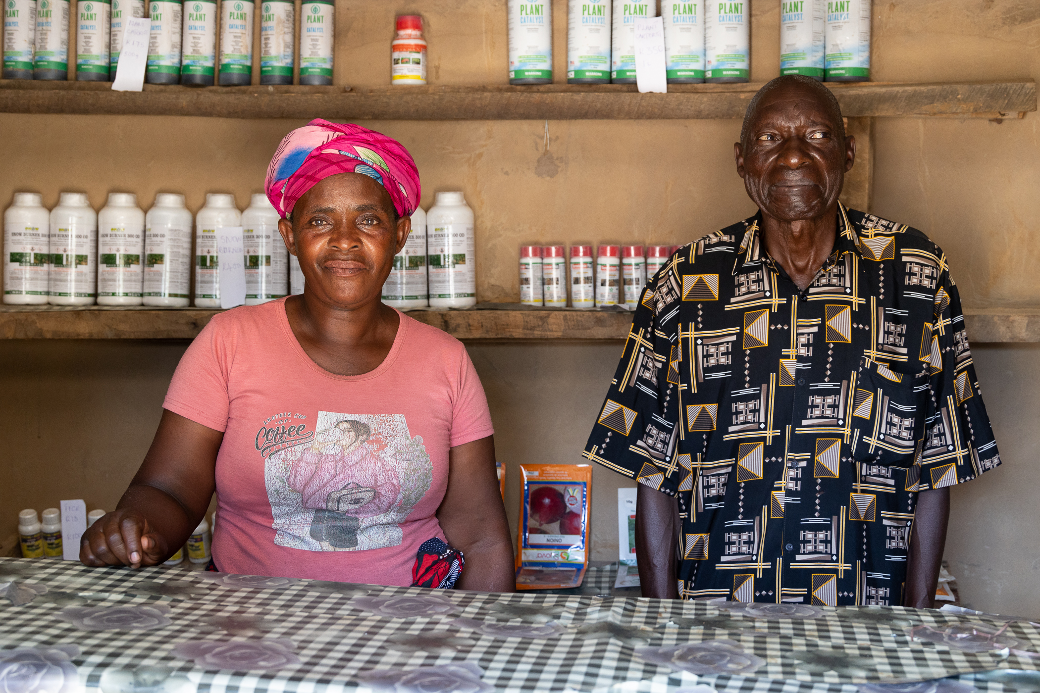 : Annie and her husband, Moses Katuta, sitting behind the counter of her shop.