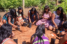 Des femmes de la communaut&eacute; travaillent ensemble pour remplir des sacs de plantation avec de la terre dans le cadre d&rsquo;une activit&eacute; de pr&eacute;paration des semis.