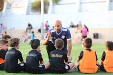 Des &eacute;l&egrave;ves se rassemblent sur le terrain tandis qu&rsquo;Haitham les guide dans une activit&eacute; de groupe visant &agrave; renforcer l&rsquo;esprit d&rsquo;&eacute;quipe et la confiance en soi.