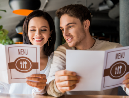 Deux personnes tenant un menu de restaurant 